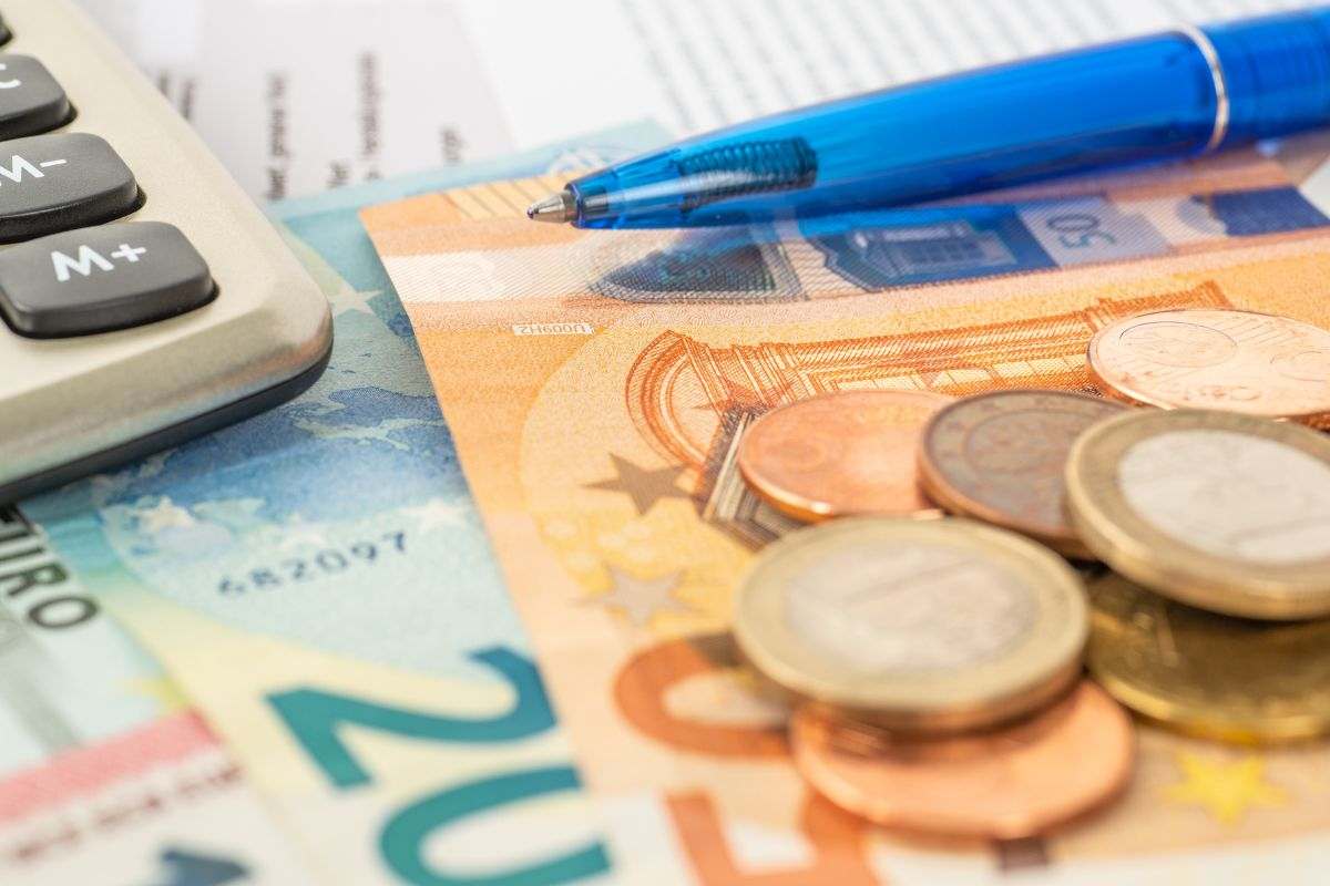 Banconote, penna e calcolatrice