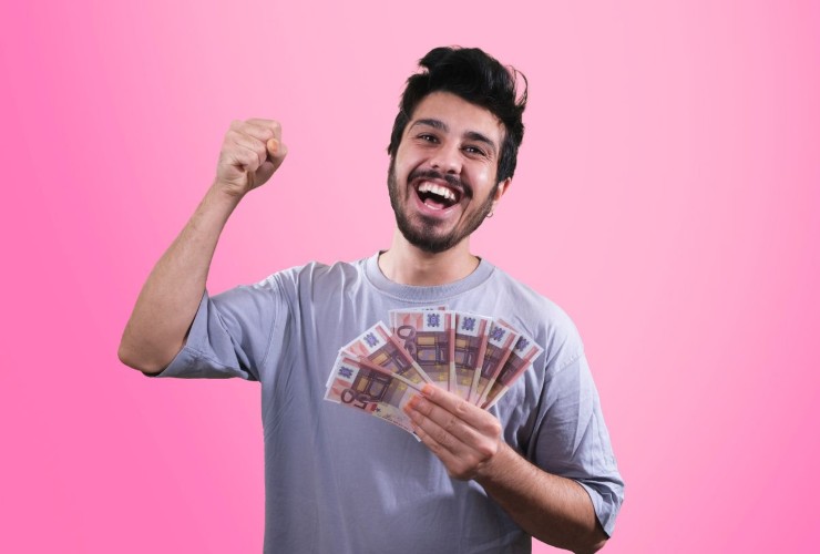 Persona che gioisce con banconote in mano