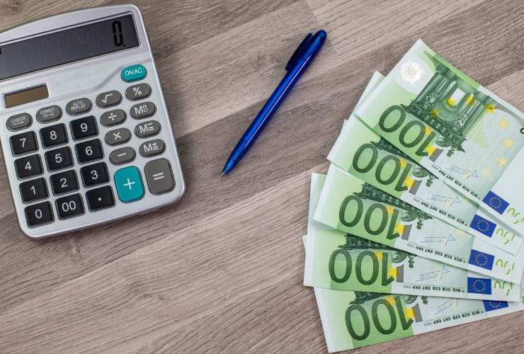 Banconote da 100 euro, penna e calcolatrice