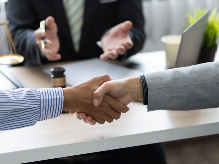 persone si stringono la mano davanti avvocato