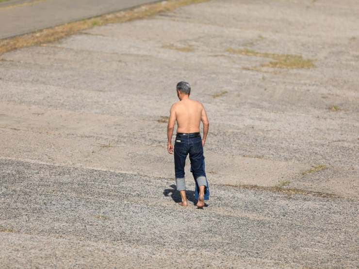 uomo a torso nudo cammina per strada
