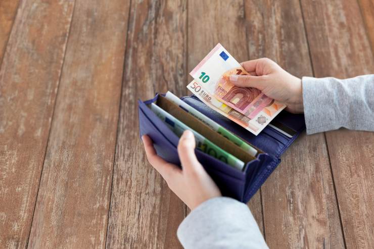 uomo con portafogli e banconote in mano