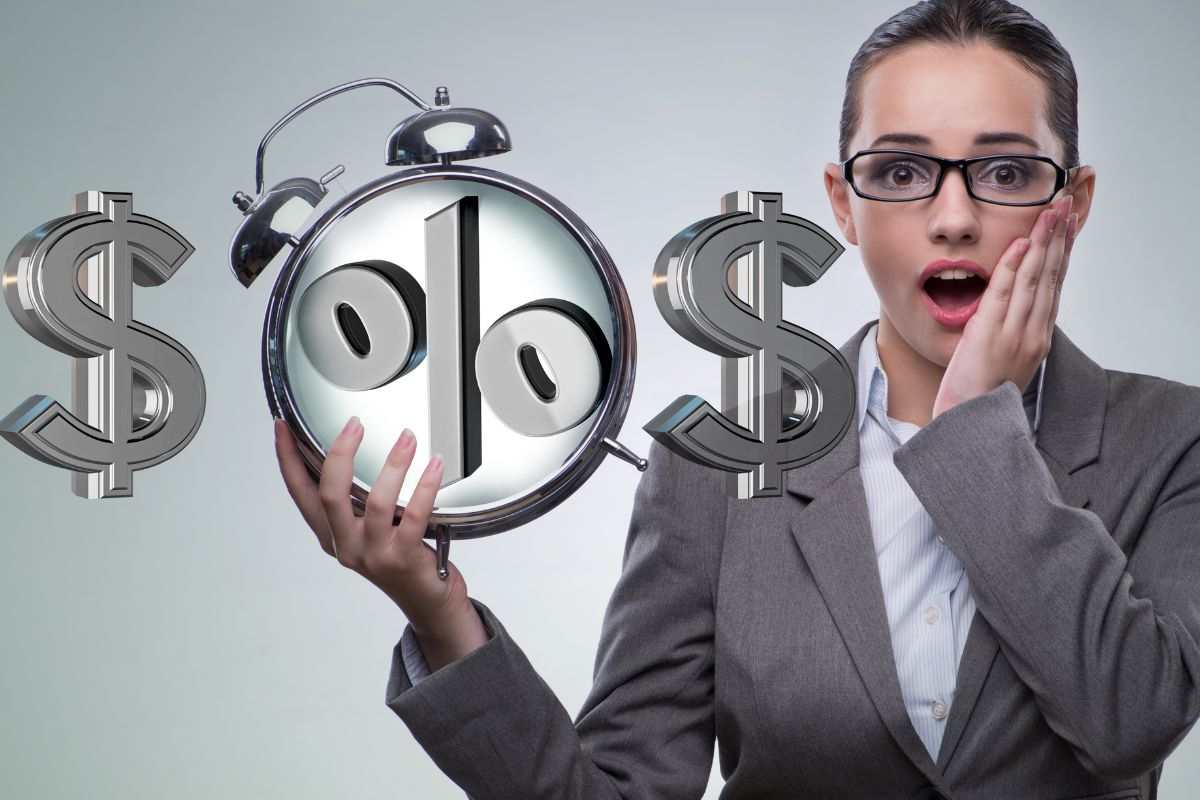 Sveglia, simbolo percentuale e simbolo dollaro con pesrona sorpresa