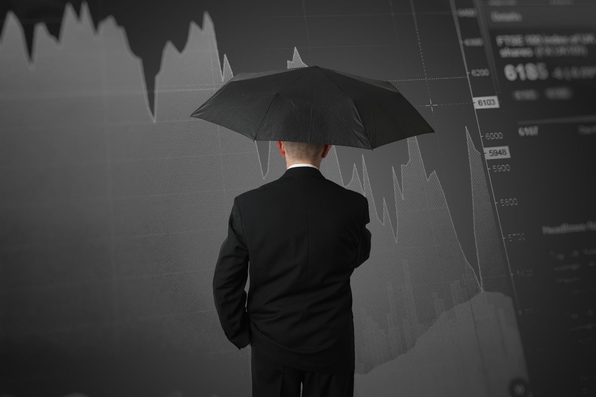 Persona che si protegge con un ombrello dalla crisi dei mercati