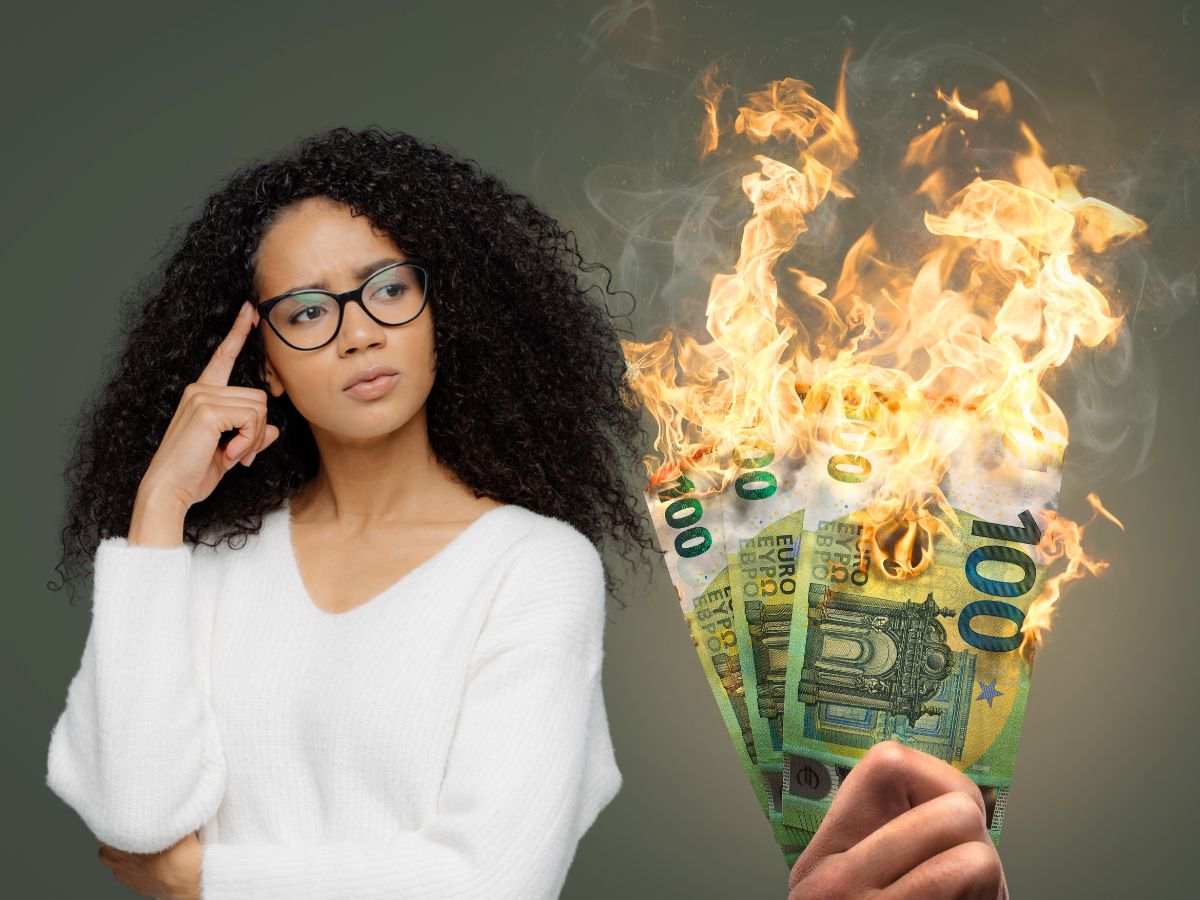 sfondo banconote 100 euro che bruciano in mano e donna che pensa