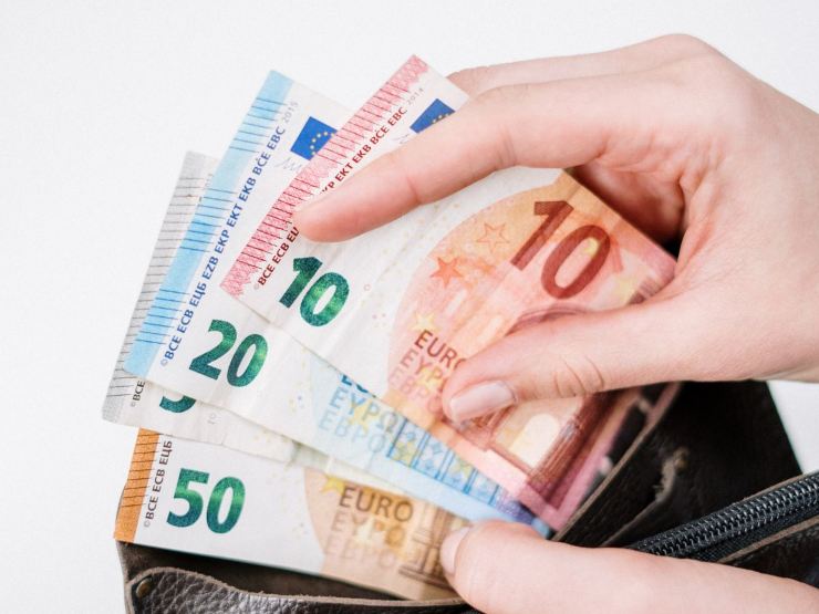 mano che prende banconote euro dal portafoglio