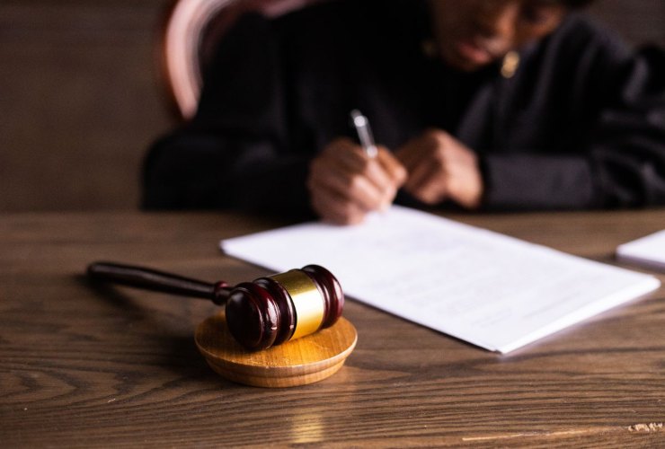 Martello giustizia e giudice che scrive una sentenza