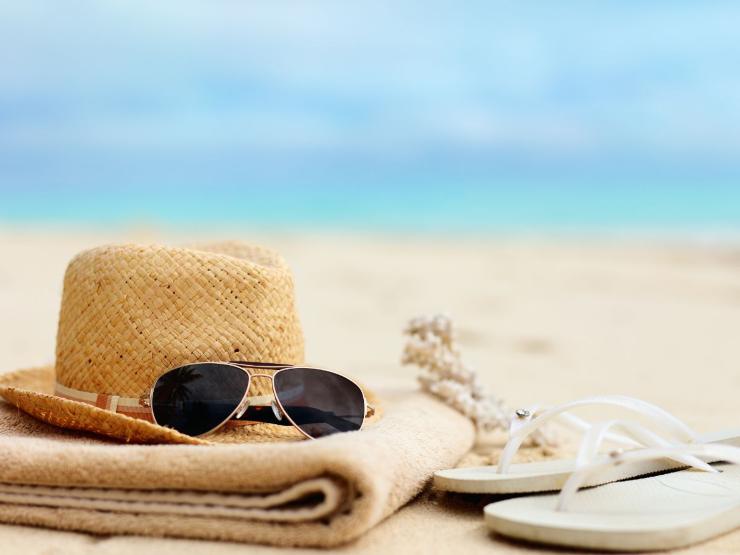 cappello, occhiali e ciabatte in spiaggia
