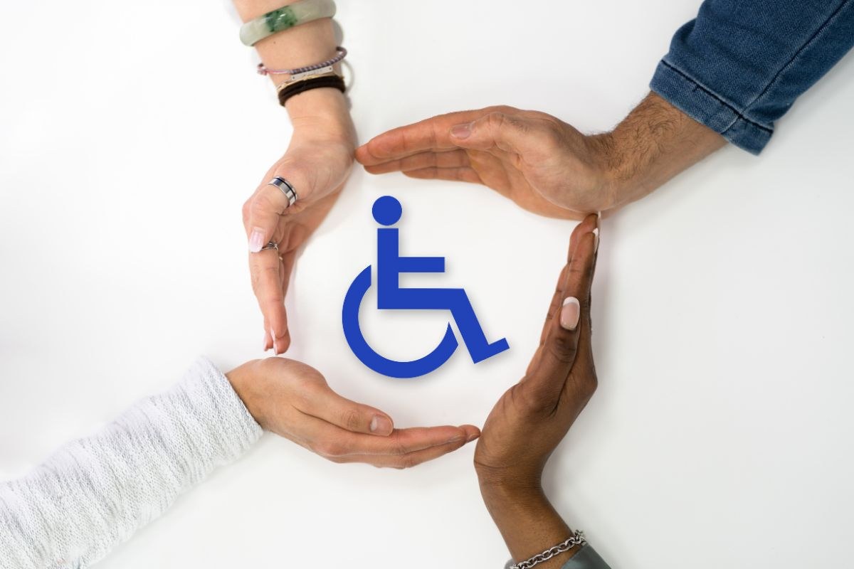 Mani che proteggono il simbolo della disabilità