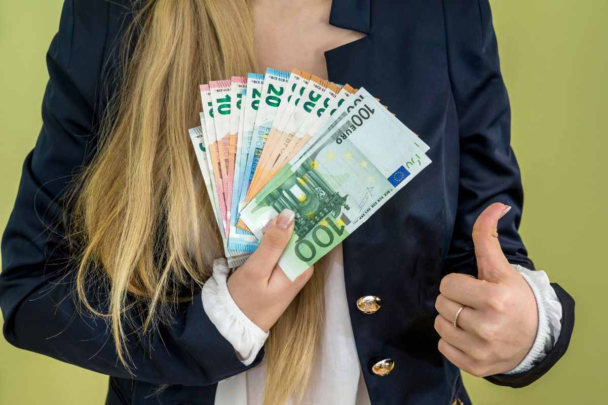 Donna che mantiene in mano delle banconote