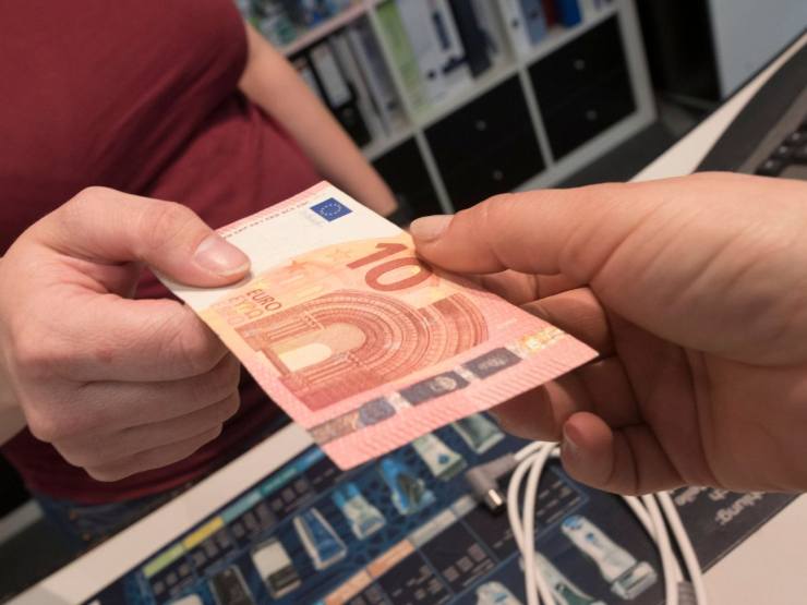 mani che si scambiano banconota 10 euro