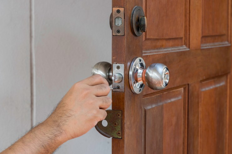 uomo controlla serratura porta di casa
