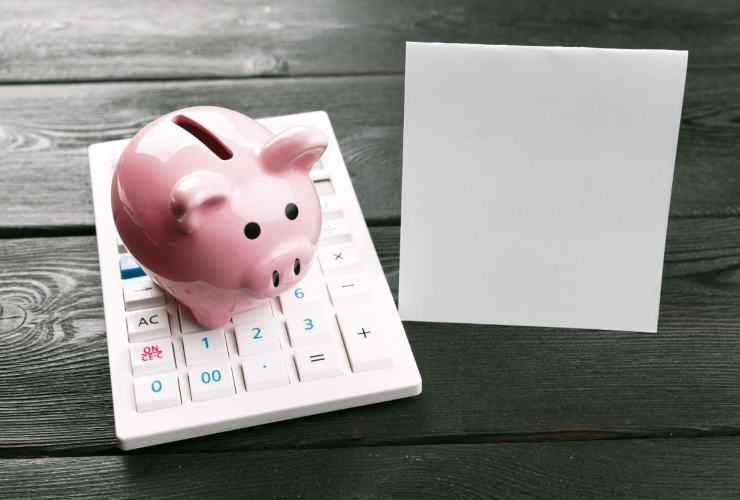 salvadanaio, calcolatrice e block notes