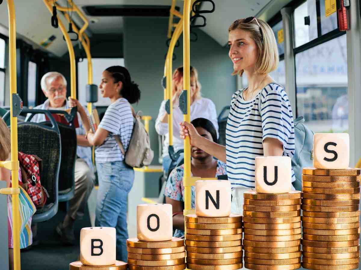 sfondo persone sul bus e scritta bonus su monete euro in ordine crescente