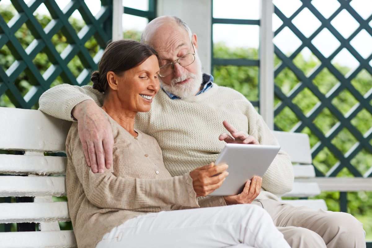 pensionati felici che leggono l'aumento della loro pensione