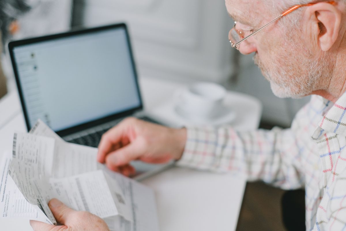 pensionato controlla cedolino pensione davanti a pc