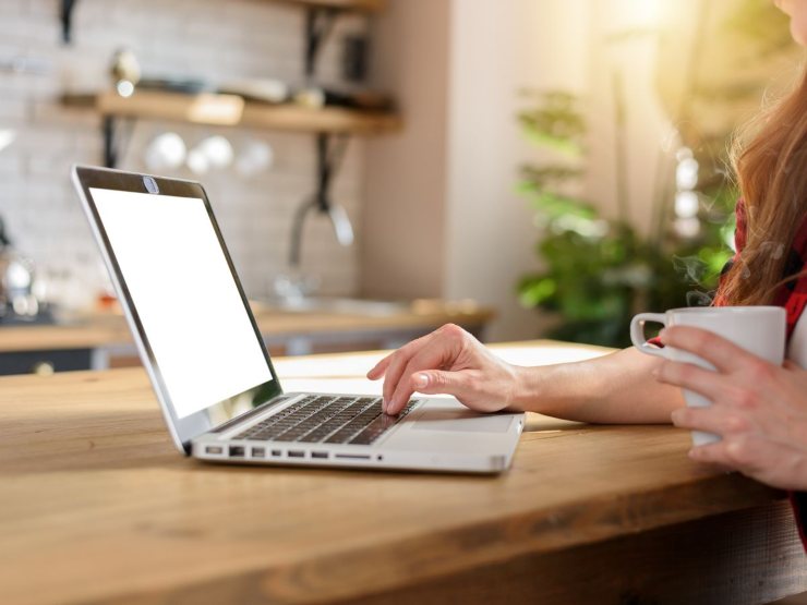 persona al pc con tazza in mano