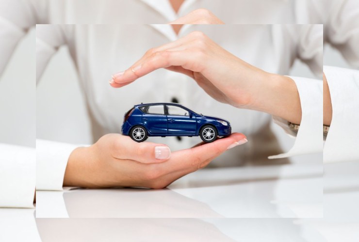 persona che mantiene fra le mani un auto in miniatura
