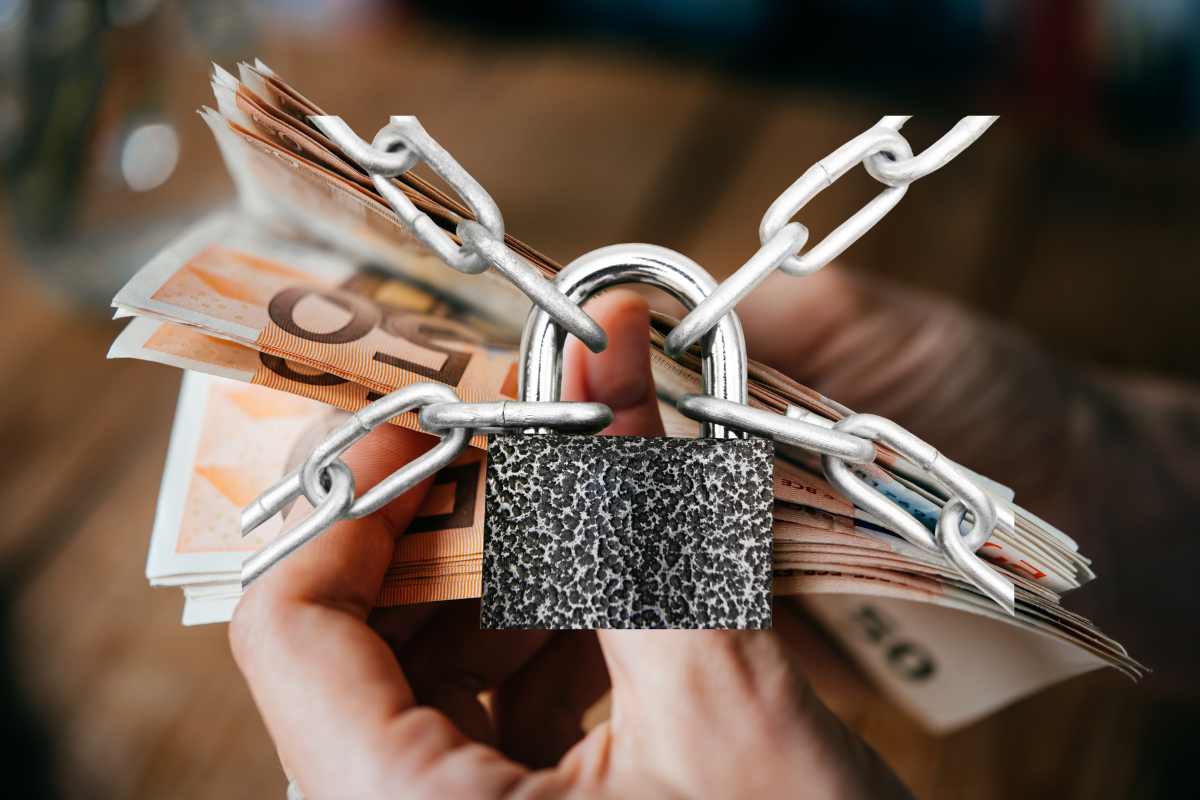 mano con banconote da 50 euro con lucchetto a coprire