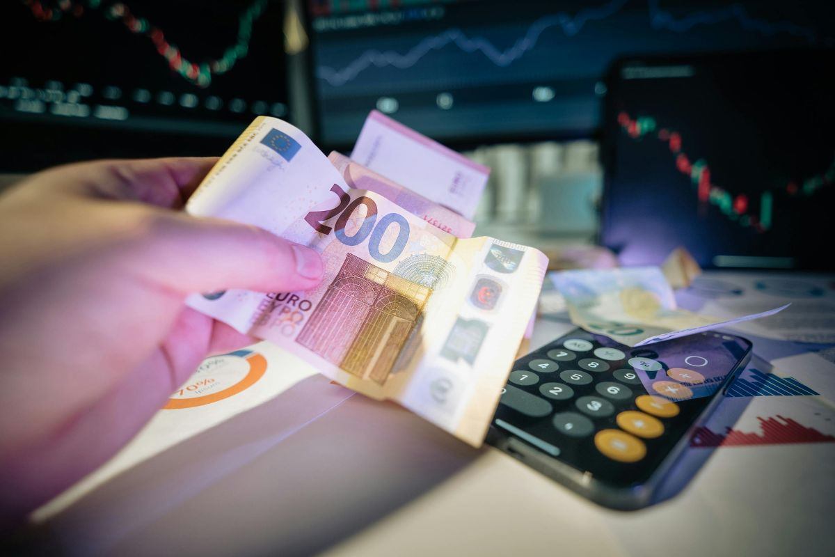 banconote, calcolatrice e monitor con grafico