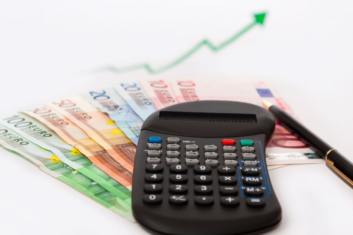Calcolatrice, freccia e banconote