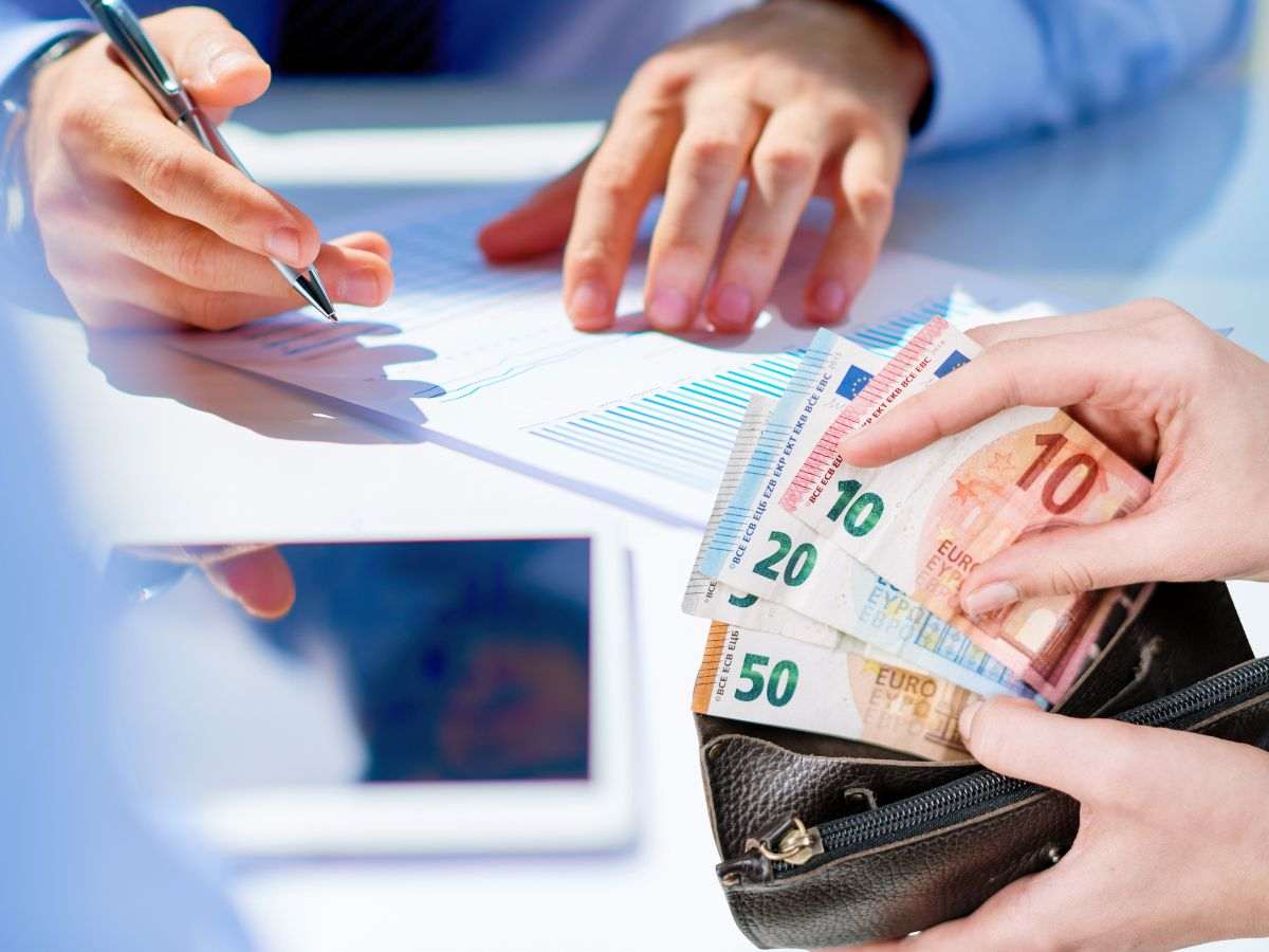 sfondo commercialista che parla e mani su banconote euro in portafoglio