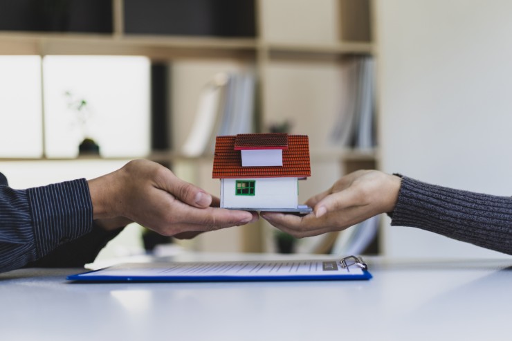 mani che tengono casa in miniatura