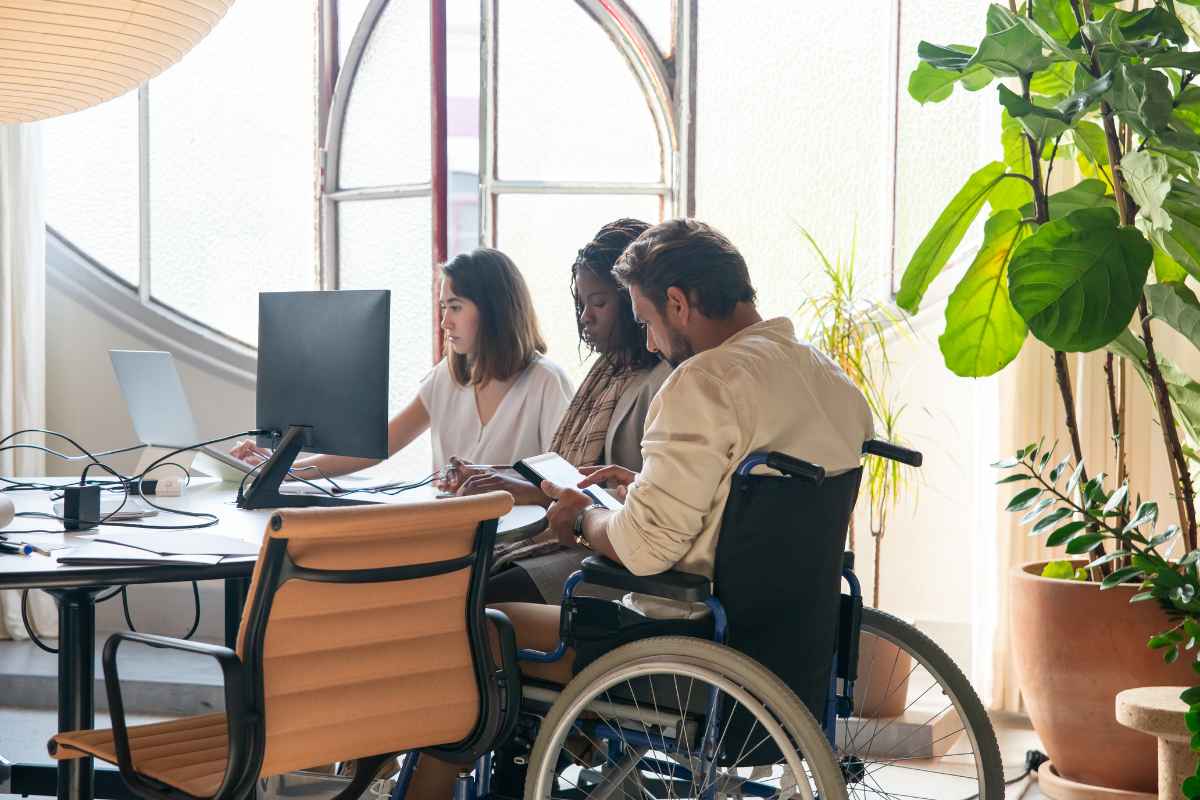 lavoratori seduti, uno dei quali in carrozzella