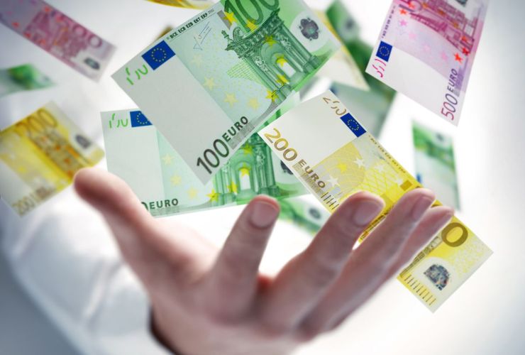 persona che mantiene in mano delle banconote