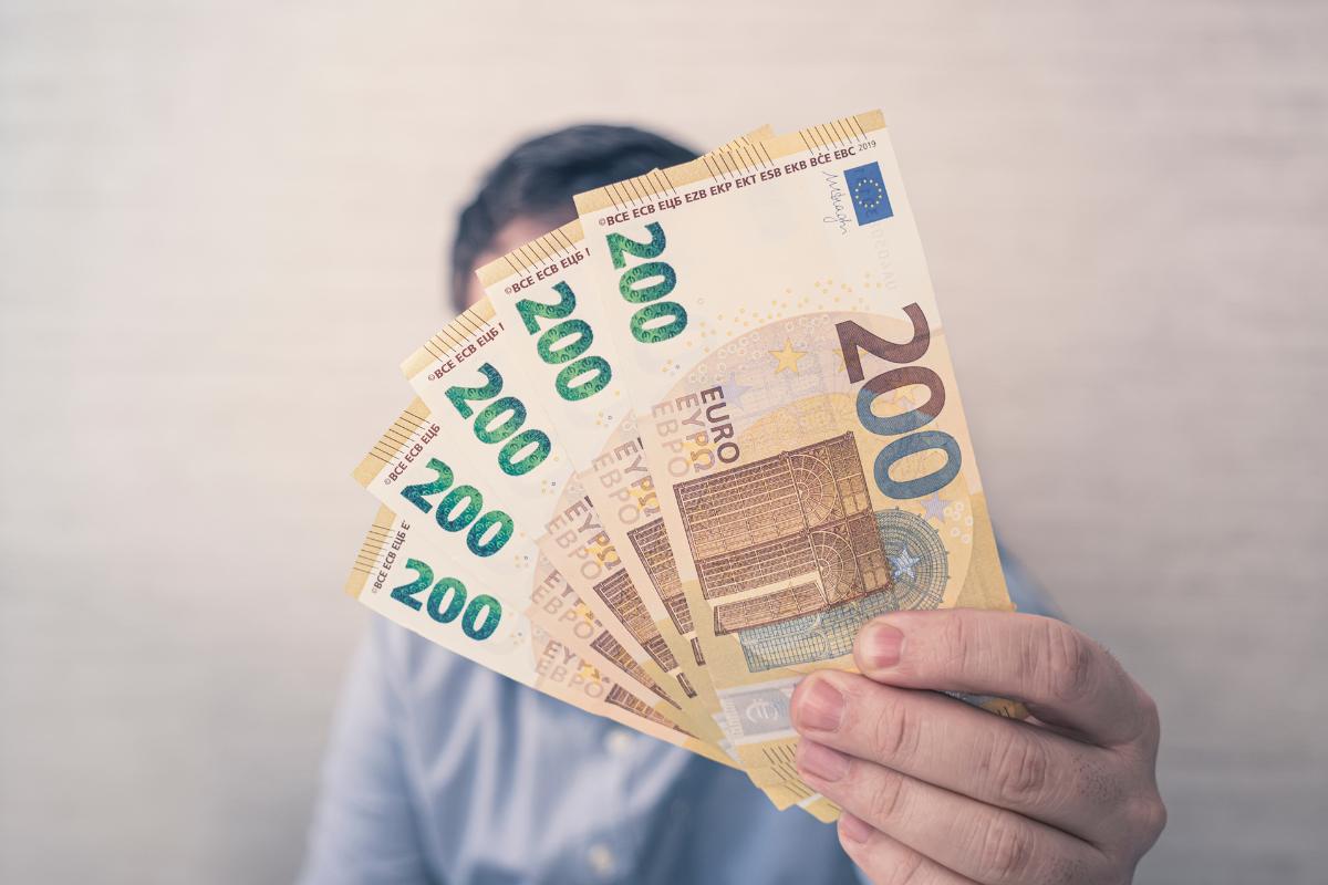 uomo tiene in mano 5 banconote da 200 euro