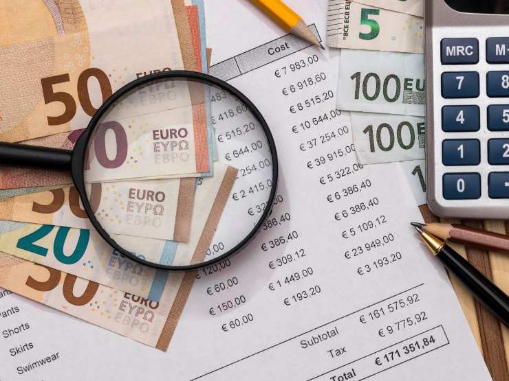 banconote, documenti, lente d'ingrandimento e calcolatrice