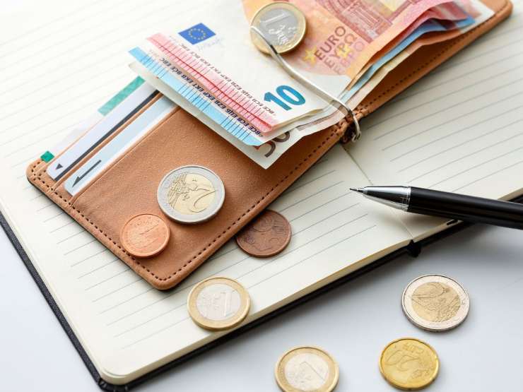 banconote e monete euro da portafoglio e agenda con penna