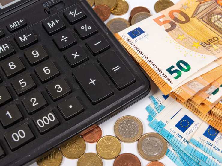 calcolatrice con banconote e monete euro