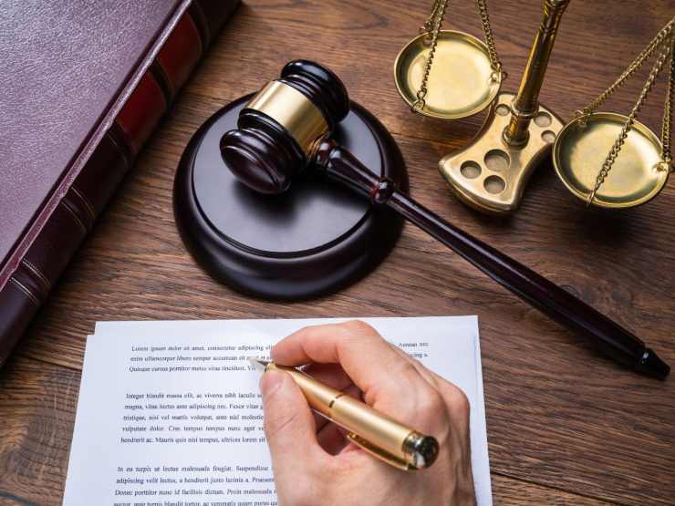 mano che scrive e simboli di legge
