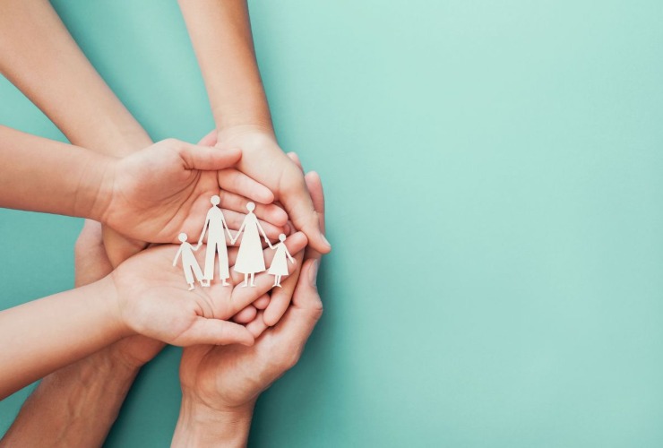 mani che proteggono le figure di una famiglia