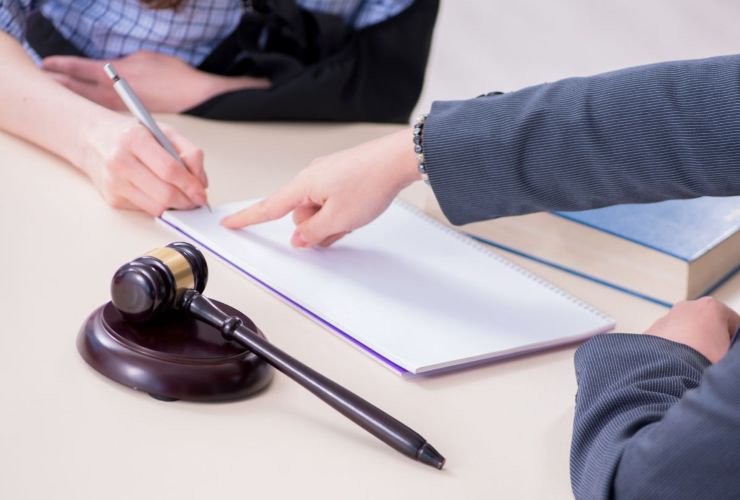 persona che legge e firma un documento per la revisione della legge 104